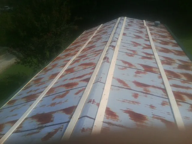 Rusted metal roof panels with new wood purlins before replacement — Storm Damage Roof Repair in Leander by Roofing Brothers